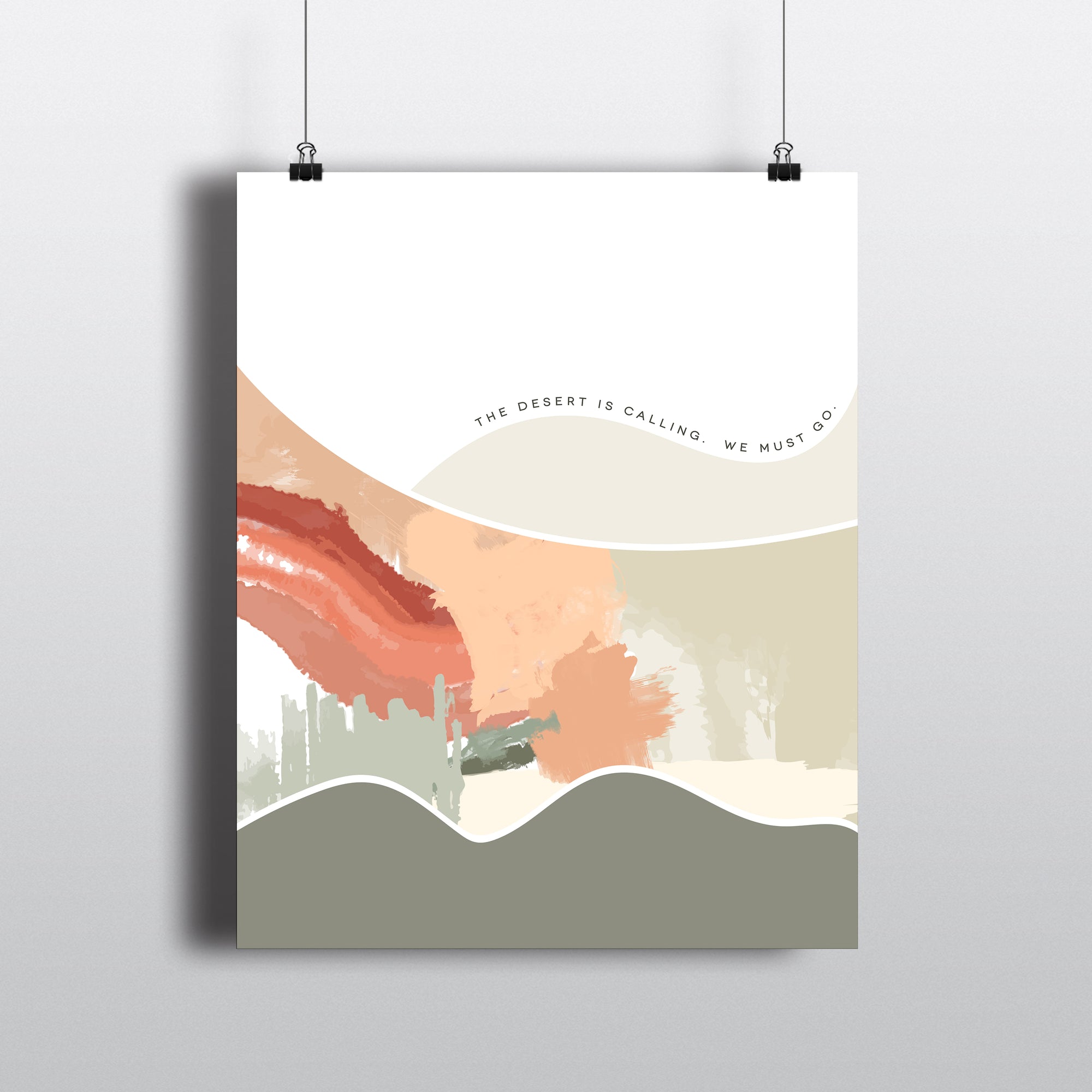 Abstract modern art print with text THE DESERT IS CALLING. WE MUST GO.  Hanging by clips.