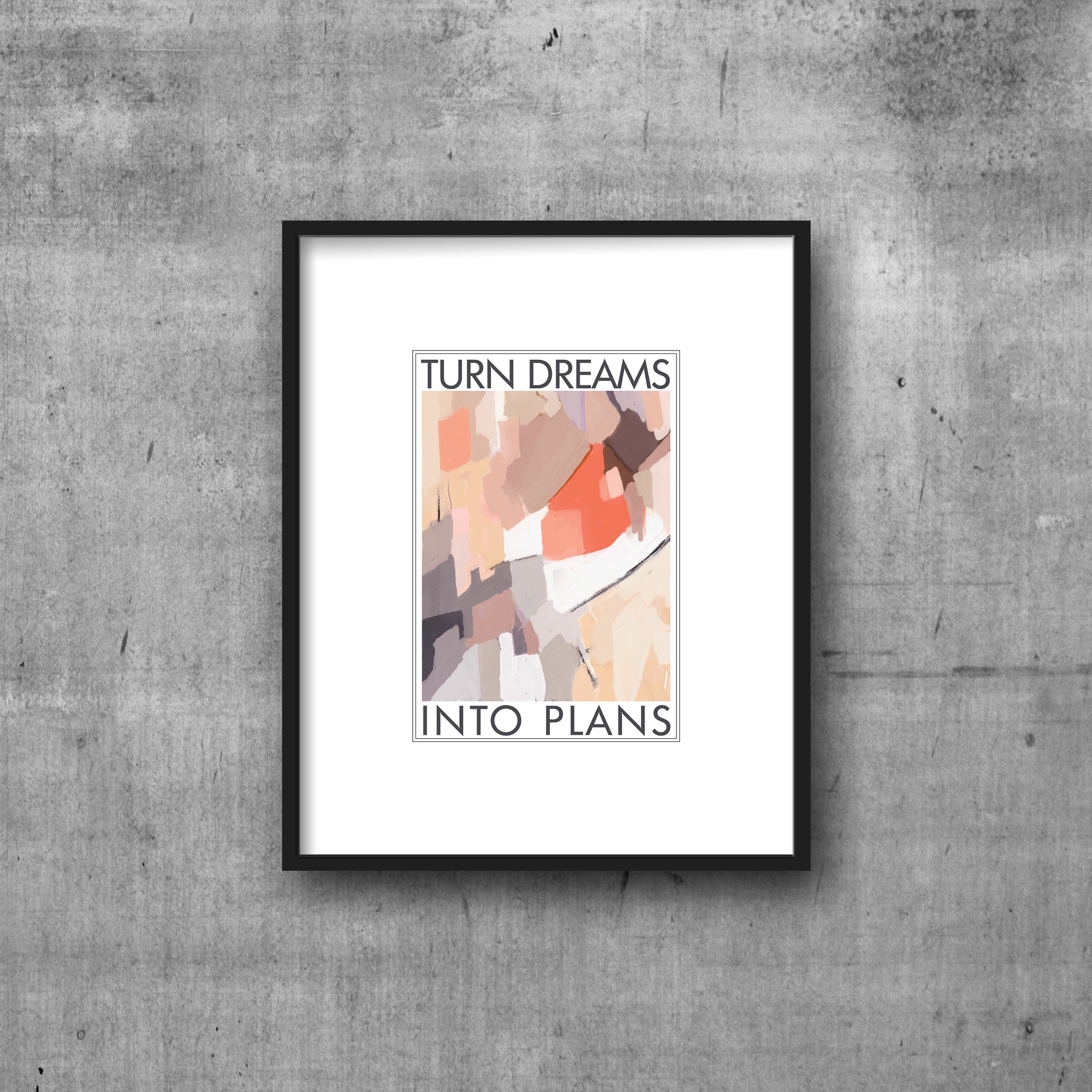 Art print with white border framing the text TURN DREAMS INTO PLANS and abstract art in shades of coral, tan lilac and mauve. Frame in black frame on cement wall.