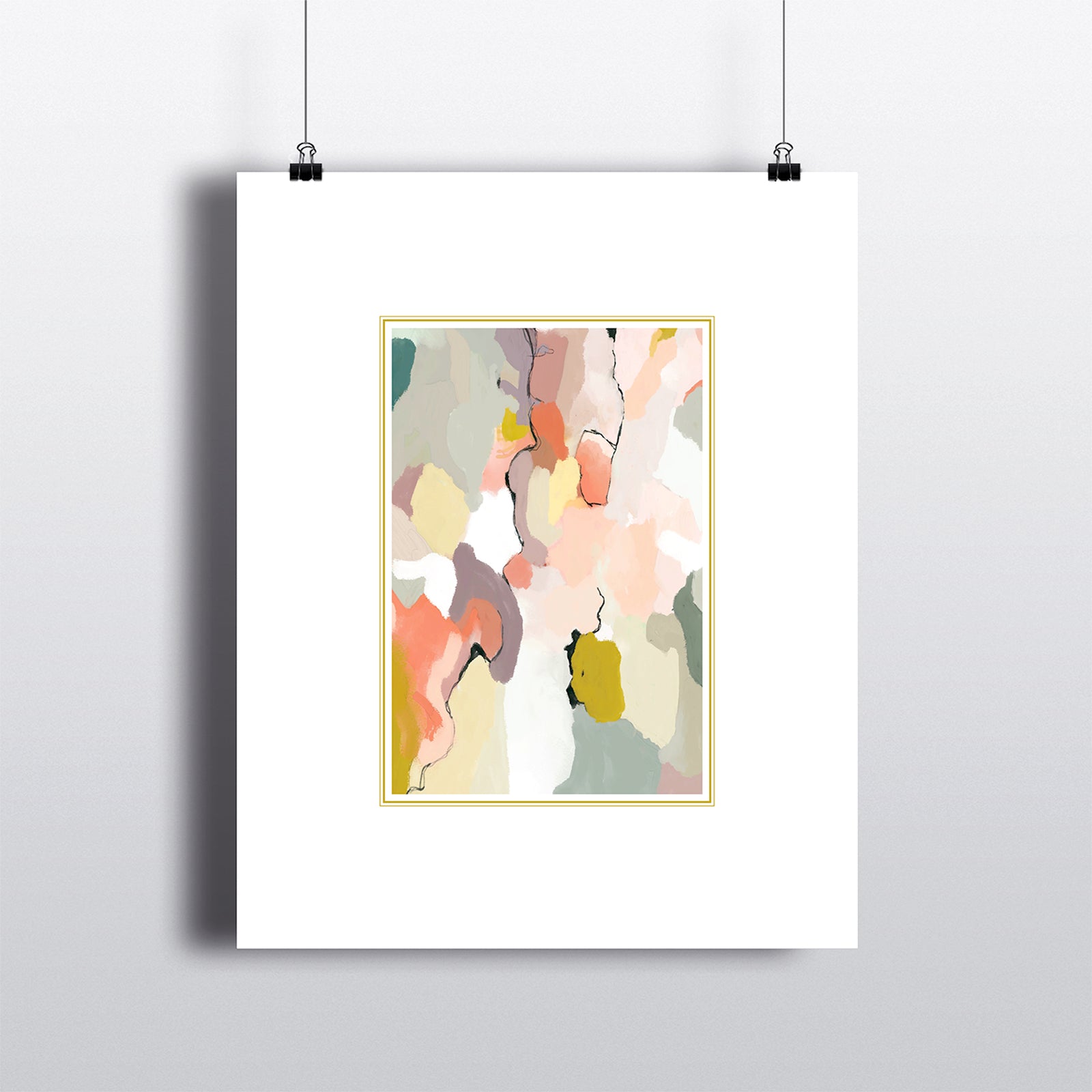 Art print with white border framing coral, sage abstract pattern with gold frame. Hanging by clips.